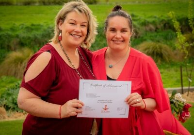 Two women holding the Red Tent Aotearoa completion certificate.